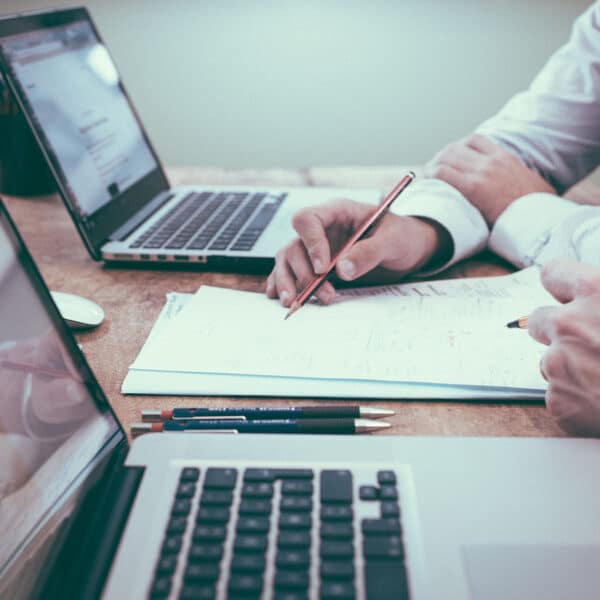 A closeup of two people working on paperwork together