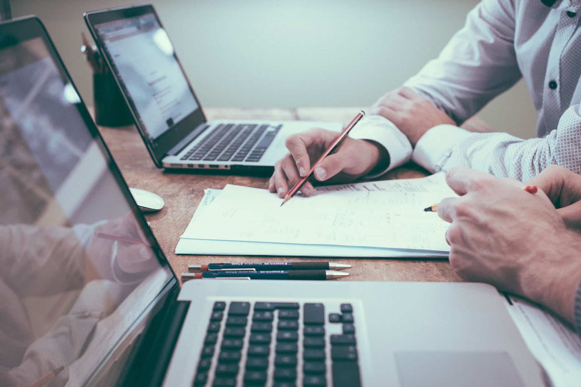 A closeup of two people working on paperwork together